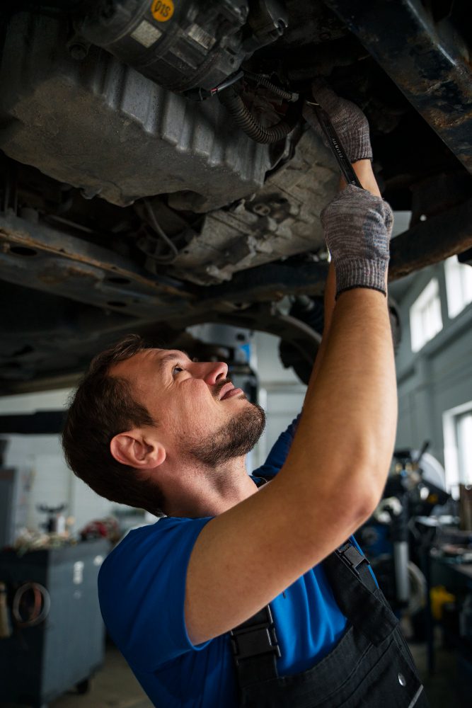 Male mechanic working on car in the auto repair shop Male mechanic working on car in the auto repair shop<br />